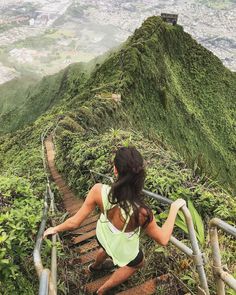 a woman climbing up some stairs in the mountains