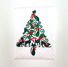 a white towel with a christmas tree and dogs on it's side, hanging from the wall