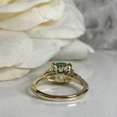 a close up of a ring with a flower in the background