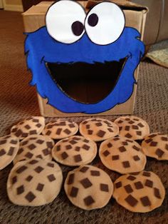 cookie monster with cookies in front of it on the floor next to a cardboard box