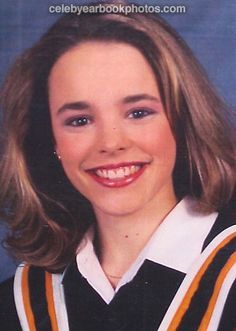 a young woman wearing a black and white uniform smiling at the camera with her hair pulled back