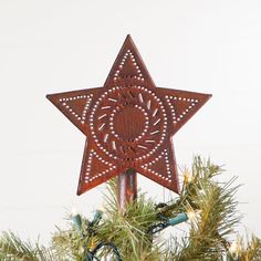 a wooden star ornament hanging from a christmas tree