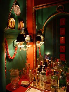 there is a vanity with many bottles on it and a mirror in front of it