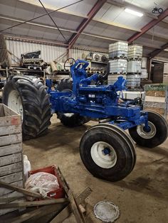 an old blue tractor sitting in a warehouse