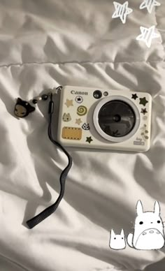 a camera is laying on a bed with white sheets