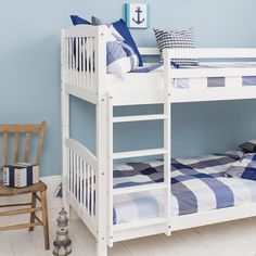 a white bunk bed with blue and white striped bedspread in a child's room