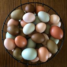 a basket filled with eggs sitting on top of a wooden table