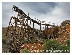 an old wooden structure sitting on top of a hill