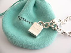 Overview: Here is a gift that she will surely adore! It is shiny, stylish, and super versatile! This piece will make someone REALLY happy! :) Offered for sale is a wonderful Tiffany & Co. Sterling Silver Signature Shopping Bag Charm Bracelet. Hanging from its bright Tiffany silver chain is a very pretty Shopping Bag charm with the words "Tiffany & Co" on it! A classic Tiffany piece that any girl will adore! Very pretty and just an adorable piece! It is simple, elegant, and classic all rolled int Designer Rectangular Bracelets As Gift, Luxury Rectangular Bracelet As Gift, Luxury Rectangular Bracelet Gift, Elegant Bracelets With Logo Charm As Gift, Elegant Bracelets With Logo Charm For Gift, Luxury Bracelets With Logo Charm As Gift, Palladium Hardware Jewelry As Gift, Palladium Hardware Bracelets As Gift, Bracelet Bangle