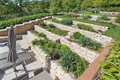 an outdoor garden with stone walls and seating area