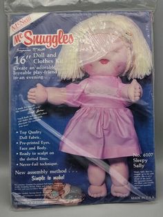 an old doll with blonde hair and pink dress on it's head, holding a knife