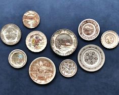 nine plates with different designs on them sitting on a blue surface