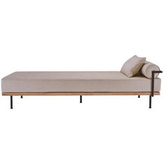 a bed with two pillows on top of it and a metal frame around the headboard