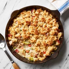 a casserole dish with meat and vegetables in it on a marble counter top