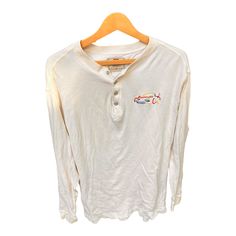 "Vintage 90s Y2K Embroidered Racing Car Henley Long Sleeve Levi's Mens Shirt L.  The \"Levi's\" logo down near the hem and the primary colored embroidered car at the chest make this cream colored henley more unique. Also love the silver metal \"levi's buttons at the collar. Size is large but you should always check the measurements against something that you like the fit of to be double sure it will fit! :) Measures 30\" long, 20\" shoulder seam to shoulder seam, 20.5\" armpit to armpit, 26\" long sleeves. Condition: There is a tiny brown mark on the end of the right sleeve, and a VERY FAINT small blue mark on the back left shoulder-- one of those things you probably will miss if you aren't looking at it with a microscope. Overall this shirt still looks great but keep in mind it is lightly White Long Sleeve Shirt With Embroidered Graphics, Casual Long Sleeve Shirt With Embroidered Graphics, Vintage White Tops With Embroidered Graphics, Vintage Long Sleeve T-shirt With Embroidered Graphics, Henley Long Sleeve, Racing Car, Mens Shirt, Race Cars, Looks Great