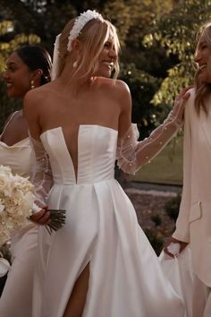 two women in wedding gowns are walking together