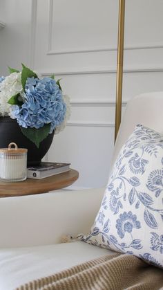 a blue and white flower arrangement on a coffee table