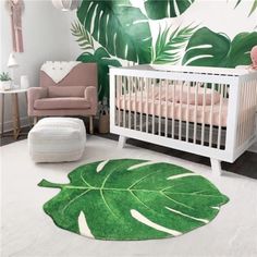 a baby's room with a large green leaf rug and pink furniture in the corner