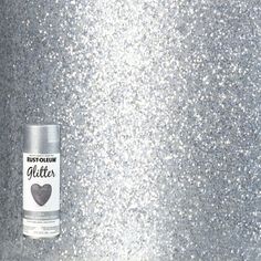 a can of glitter sitting on top of a metal table next to a white wall