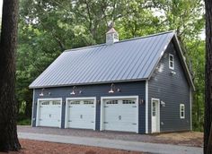 a two car garage in the middle of some trees