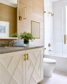 a white bathroom with gold accents and marble counter tops