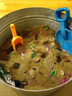 a metal bucket filled with sand and toys