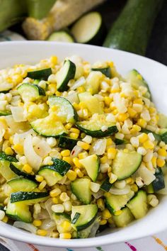 a white bowl filled with corn and zucchini