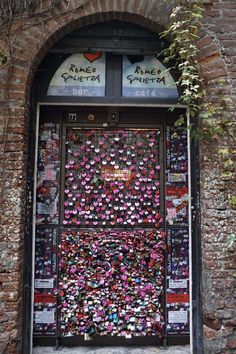 the entrance to an old building with lots of love locks on it