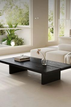 a living room with white couches and a black coffee table