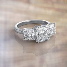 three stone diamond ring on wooden surface with reflection