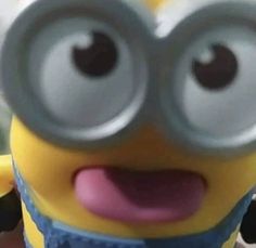 a close up of a minion holding a cell phone in front of the camera