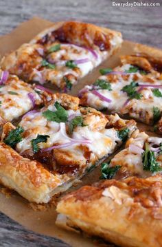 the pizza is cut into eight pieces and has cheese, onions, and herbs on it