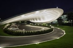 a curved road with cars parked on it at night time in front of a building