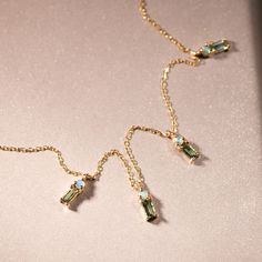 A stone and gold chain necklace lies flat on a shimmering background. It has opals and tourmalines conjoined by gold. Pearl And Diamond Earrings, Green Sea, Tennis Bracelet Diamond, Engagement Jewelry, Engagement Ring Wedding Band, Diamond Bracelets, Delicate Necklace, Bracelets And Charms, Wedding Ring Bands