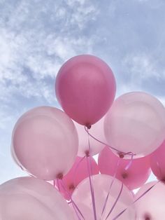 a bunch of pink balloons floating in the air on a clear day with blue sky