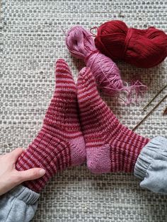 someone is knitting socks with yarn and needles