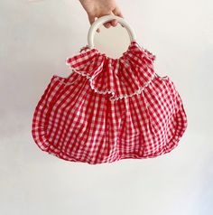 Vintage Red Gingham Cotton Bag. This charming piece features a ruffled top with decorative buttons, circular metallic handles, and a spacious interior. Made from a cotton fabric, it showcases a classic red and white vichy pattern. CONDITIONS Excellent Conditions DESCRIPTION No brand tag Material: Cotton (no composition label inside) Color: Red, White MEASUREMENTS  Height 36 cm (14") Length 52 cm (20.4") Drop 12 cm (4.7") measurements are taken seam to seam with the item laid flat (I suggest comp Red Spring Picnic Bag, Spring Picnic Cotton Bag, Summer Cotton Gingham Bags, Summer Gingham Cotton Bags, Gingham Cotton Bags For Summer, Red Summer Picnic Bag, Cotton Summer Picnic Bag, Summer Cotton Bag For Picnic, Red Cotton Bag For Summer