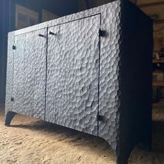 a black cabinet sitting in the middle of a room next to a wall and floor