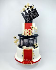 a three tiered cake decorated with film reel and stars