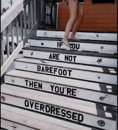 a woman walking up some steps with words painted on the steps and handrails that read if you are not barefoot, then you're overdressed