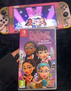 the wii game bratz is being held up by someone's hand in front of it