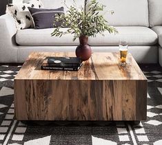 a living room with a couch, coffee table and vase on the end tables in front of it