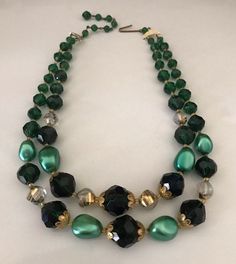 This light weight variegated bright emerald green and pearly green light weight bead necklace features two layers of very green and clear faceted beads. The shortest layer is 19 inches including the adjustable bead and hook closure. There is a small adjustable 4 inch bead and hook clasp in the back. The hook is signed West Germany. The biggest focal beads are 15mm wide. This is a fun layered vintage choker in great condition. I specialize in finding high quality vintage jewelry. Please browse my Vintage Choker, Focal Beads, Le Crochet, Copper Bracelet, Enamel Flower, Hook Clasp, Creative Jewelry, West Germany, Focal Bead