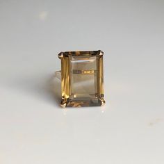 A vintage 9 carat gold ring, displaying a lovely sized Tourmaline. The stone is held by a simple style gold setting that frames the stone perfectly, holding it nice and snug. CONDITION: Wear consistent with age and use. Please see photos for more detail. BAND WIDTH: 1.5mm SETTING HEIGHT: 10mm STONE FACE: 20mm X 15mm RING SIZE: UK: M | US: 6 1/4 WEIGHT: 6.3 grams (UQZ) (696782) Classic Yellow Gold Emerald Cut Crystal Ring, Classic Octagon Topaz Ring With Prong Setting, Classic Emerald Ring With Rectangular Stone For Formal Occasions, Classic Emerald Ring With Rectangular Stone For Formal Events, Classic Topaz Ring With Octagon Prong Setting, Formal Solitaire Crystal Ring With Open Design, Solitaire Crystal Open Ring For Formal Occasions, Formal Solitaire Crystal Open Ring, Classic Open Crystal Ring For Formal Occasions