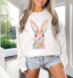 We absolutely love this beautiful and trendy watercolor bunny print for spring and Easter. It's the perfect whimsical and cozy sweatshirt for your wardrobe.  A sturdy and warm sweatshirt bound to keep you warm in the colder months. A pre-shrunk, classic fit sweater that's made with air-jet spun yarn for a soft feel and reduced pilling. * 50% cotton, 50% polyester * Pre-shrunk * Classic fit * 1x1 athletic rib knit collar with spandex * Air-jet spun yarn with a soft feel and reduced pilling * Doub Spring Crew Neck Tops With Bunny Design, Casual White Tops With Watercolor Print, Casual White Top With Watercolor Print, White Bunny Print Top For Spring, White Bunny Print Crew Neck Top, White Crew Neck Tops With Bunny Print, White Crew Neck Top With Bunny Print, Casual White Easter Tops, Casual White Tops For Easter