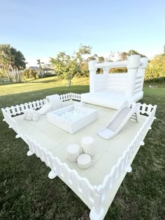 a large white couch sitting on top of a lush green field