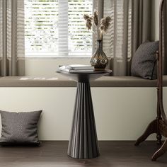 a table with a vase on it in front of a window sill and some pillows