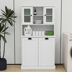 a white cabinet next to a washer and dryer in front of a wall