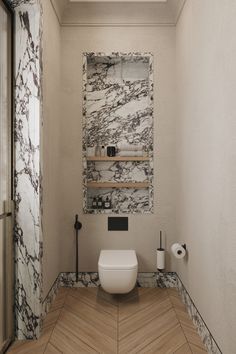 a white toilet sitting in a bathroom next to a wooden floor