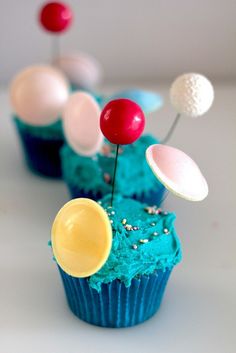 cupcakes with blue frosting and colorful decorations